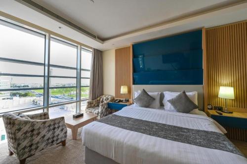 a hotel room with a bed and a large window at Al Mansour Suites Hotel in Doha