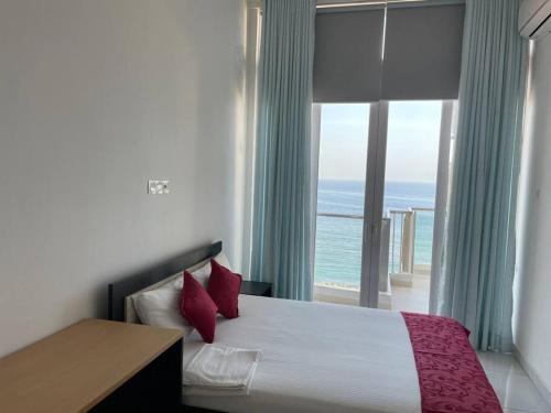 a bedroom with a bed with a view of the ocean at Spectacular Sea View 3 Bedrooms Apartment in Colombo