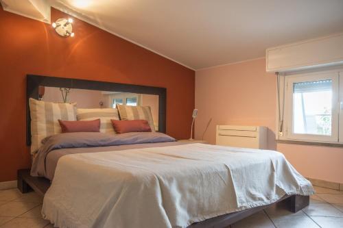 a bedroom with a large bed with orange walls at APPARTAMENTO CAMPOVOLO in Reggio Emilia