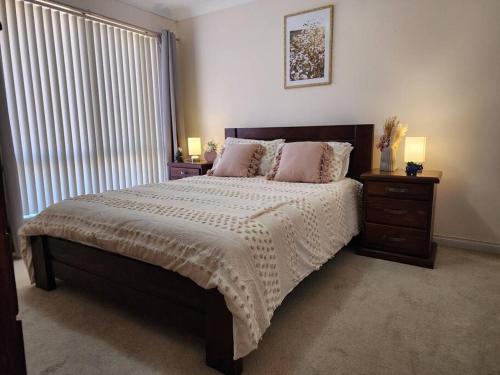 a bedroom with a bed with two lamps and a window at The Golfers Rest. in Kalgoorlie