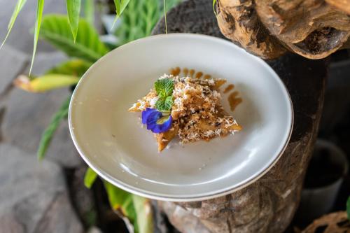 a white plate with a piece of food on a table at Aranka Tempasan in Sangyang