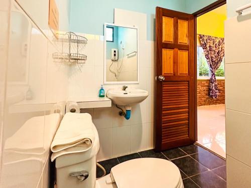 uma casa de banho com um WC, um lavatório e um espelho. em Lanta Baan Nok Resort em Ko Lanta