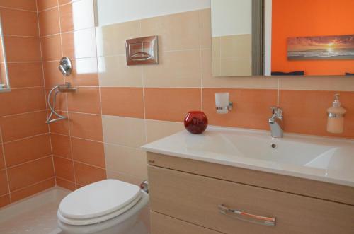 a bathroom with a toilet and a sink and a mirror at Campagne Iblee in Ragusa