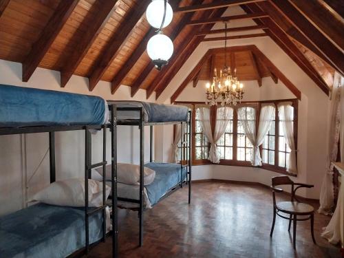 Zimmer mit 3 Etagenbetten und einem Kronleuchter in der Unterkunft Why Not Guemes in Cordoba