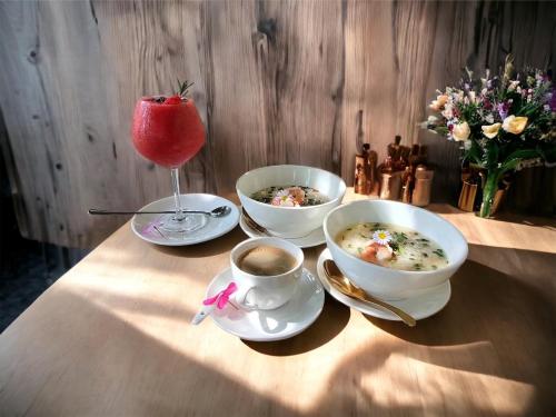 2 bols de soupe et une tasse de café sur une table dans l'établissement Payim farmstay, 