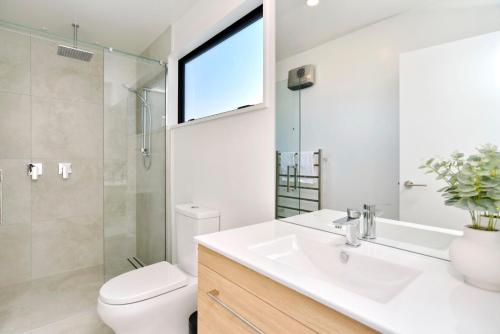 a bathroom with a sink and a toilet and a window at Chatham Street - Christchurch Holiday Homes in Christchurch