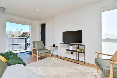 a living room with a couch and a tv at Chatham Street - Christchurch Holiday Homes in Christchurch
