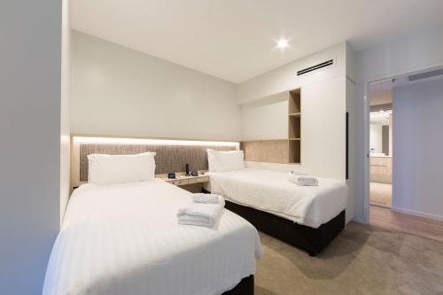 duas camas num quarto de hotel com paredes brancas em Accommodate Canberra - Metropolitan 70 em Canberra