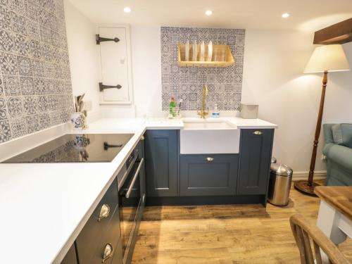 cocina con fregadero y encimera azul y blanco en Gelli Bach at Gelli Las, en Llanbedr