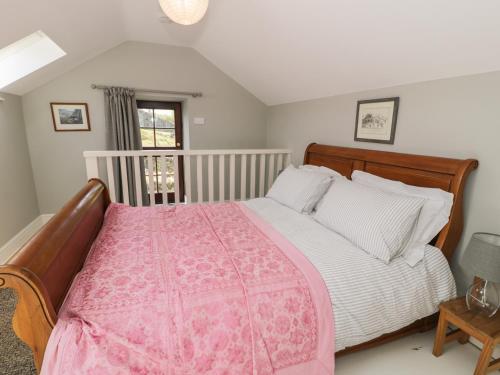 a bedroom with a bed with a pink blanket at Gelli Bach at Gelli Las in Llanbedr