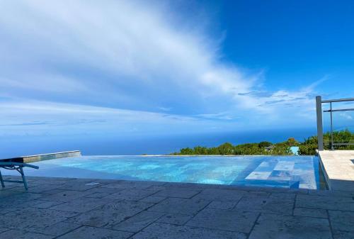 a swimming pool with the ocean in the background at Villa Mahot in Petite Île