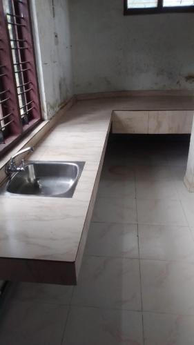a kitchen with a sink in the middle of a room at Mountain View cottage Mankulam in Munnar