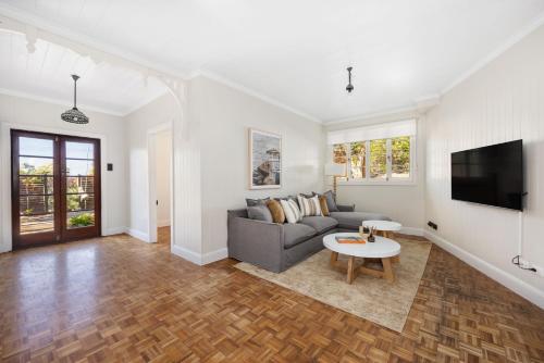 a living room with a couch and a tv at Pacific Terrace Beach House in Coolum Beach