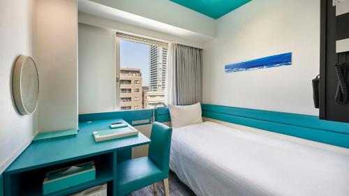 um pequeno quarto com uma cama e uma secretária em DEL style Osaka Shin Umeda by Daiwa Roynet Hotel em Osaka