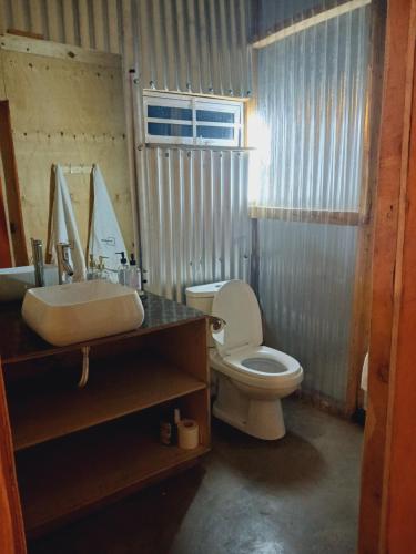 ein Bad mit einem Waschbecken und einem WC in der Unterkunft The Cascades Cabin Nakuru in Nakuru