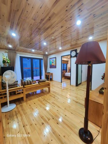 a living room with a wooden ceiling and a lamp at SaPa Retreat Condotel in Sa Pa
