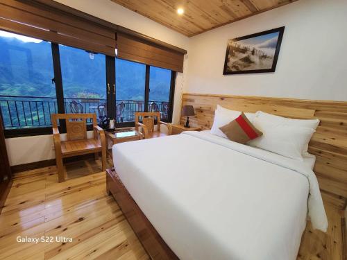 a bedroom with a large white bed and a balcony at SaPa Retreat Condotel in Sa Pa