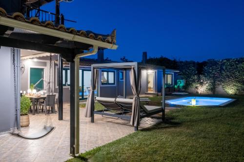 einen Hinterhof mit einem Haus und einem Pool in der Nacht in der Unterkunft Casa Del G in Metókhi
