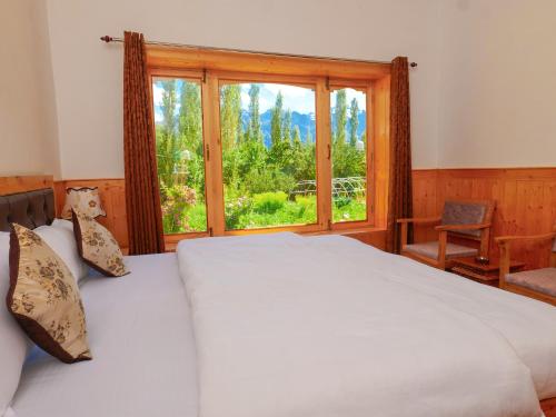 a bedroom with a large bed and a window at De Khama in Nubra