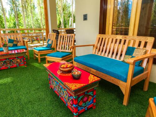 a porch with chairs and a table with a bowl of fruit at De Khama in Nubra