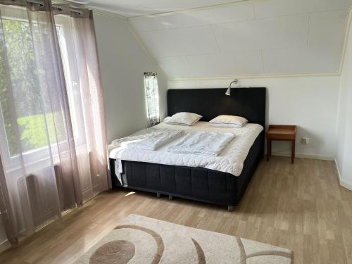 1 dormitorio con 1 cama grande y cabecero negro en Welcome to Vimmerby where you live close to nature in a quiet environment but still close to Astrid Lindgren's World en Vimmerby
