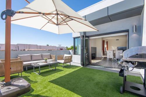 un patio con sofá y sombrilla en Regency Modern Apartments en Los Ángeles