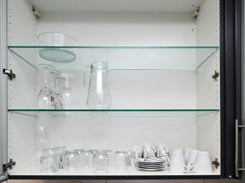 a glass cabinet with glasses and dishes on it at Ferienwohnung & Aparts am Schloss Park in Essen