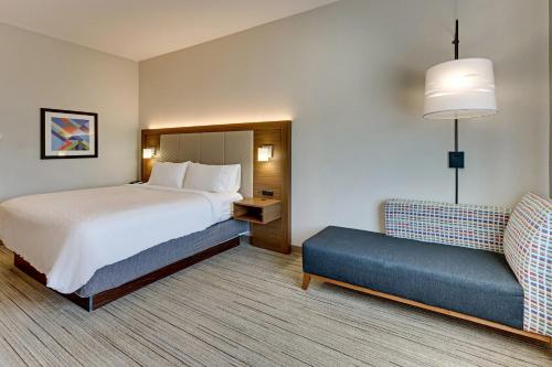 a hotel room with a bed and a couch at Holiday Inn Express Hotel and Suites Weatherford by IHG in Weatherford