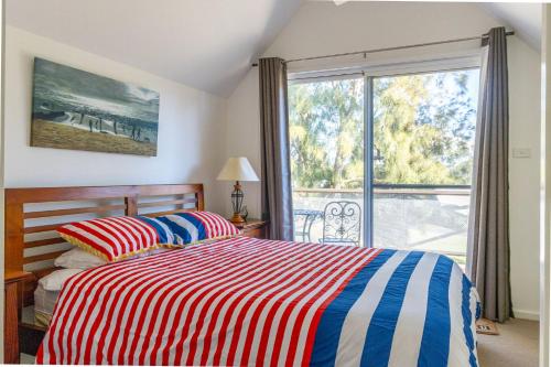 Coral Cottage في Berrara: غرفة نوم بسرير ونافذة كبيرة
