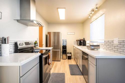 a large kitchen with stainless steel appliances and white counter tops at 5 Beds, 2 Full Baths, w/Gazebo, w/Fenced Backyard in Yuba City