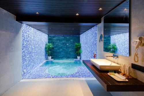 a bathroom with a jacuzzi tub with plants in it at MGM Beach Resorts East Coast Road in Chennai