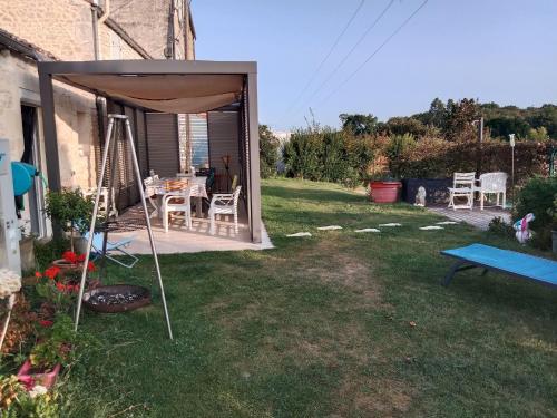 a backyard with an umbrella and a table and chairs at Le Logis du Bouil in Champagne