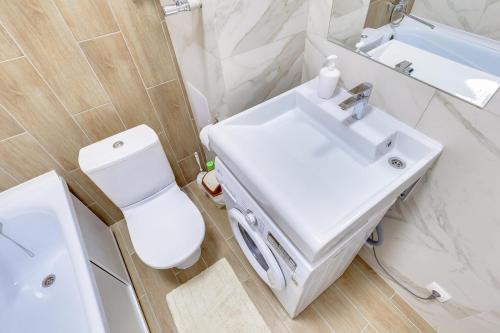 La salle de bains est pourvue d'un lavabo blanc et de toilettes. dans l'établissement Asaapart Vernyi Room 1, à Almaty