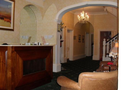 a hallway of a hotel with a chandelier at Woodlands Hotel in Spalding