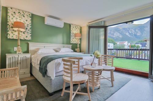 a bedroom with a bed and a table and chairs at Lavender Manor Guest Lodge in Hermanus