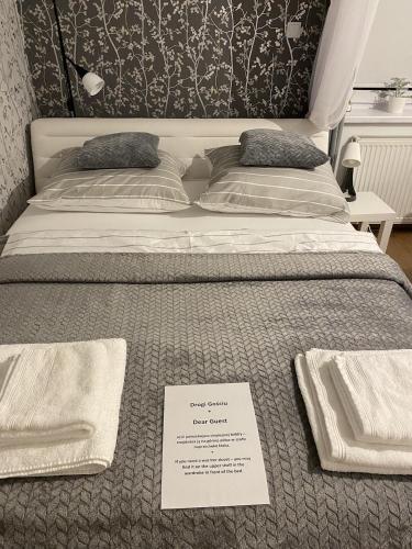 a bed with a sign sitting on top of it at Apartament Czytelnia - parking gratis, klimatyzacja in Poznań