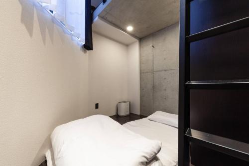 東京的住宿－LAPiS AkasakaⅡ，小房间设有两张床和一个架子