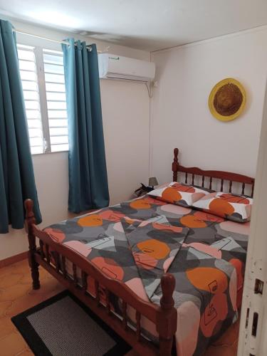 a bedroom with a bed with a colorful quilt at MAISON DE VACANCES KAZ A LOLO in Port-Louis