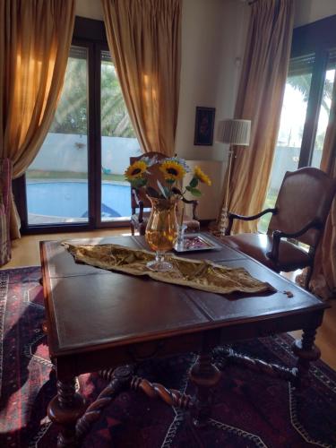 a wooden table with a vase of flowers on it at Villa by the river near meteora in Tríkala