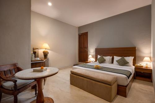 a hotel room with a bed and a table at Tapa Tepi Kali Canggu in Canggu