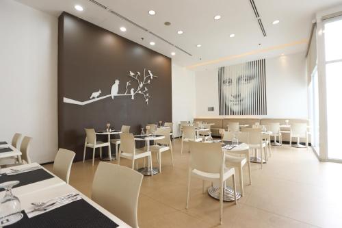 a restaurant with tables and chairs and a large wall at Privato Ortigas in Manila