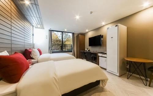 um quarto de hotel com duas camas e uma televisão em Maron Hotel Nampo em Busan