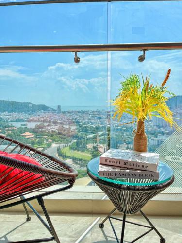 a table with books and a chair in front of a window at Căn hộ Studio The Sóng Vũng Tàu in Vung Tau