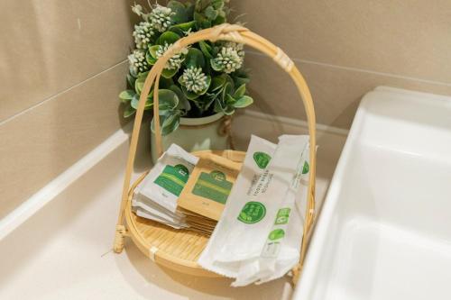 a basket with toilet paper and a potted plant at Căn hộ Studio The Sóng Vũng Tàu in Vung Tau
