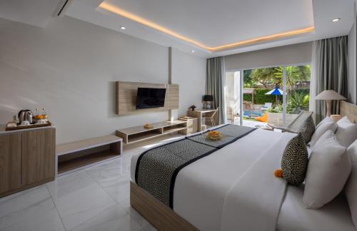 a bedroom with a large bed and a television at Tapa Tepi Kali Canggu in Canggu
