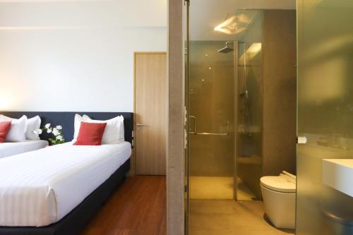 une chambre d'hôtel avec un lit et une douche dans l'établissement Privato Quezon City, à Manille