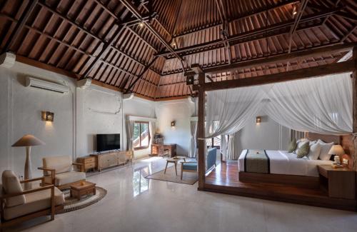a bedroom with a bed and a living room at Tapa Tepi Kali Canggu in Canggu