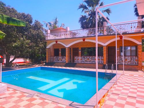 a swimming pool in front of a house at Resort - Toms Hideout in Mumbai