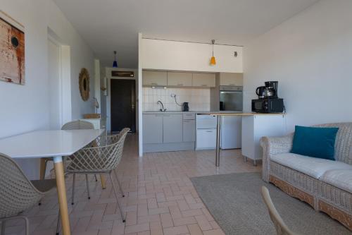 une cuisine et un salon avec un canapé et une table dans l'établissement L'Escoublac, à La Baule