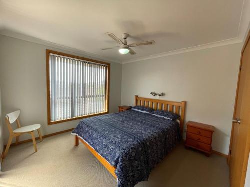 a bedroom with a bed and a window at Seaview Townhouse 1 in South West Rocks